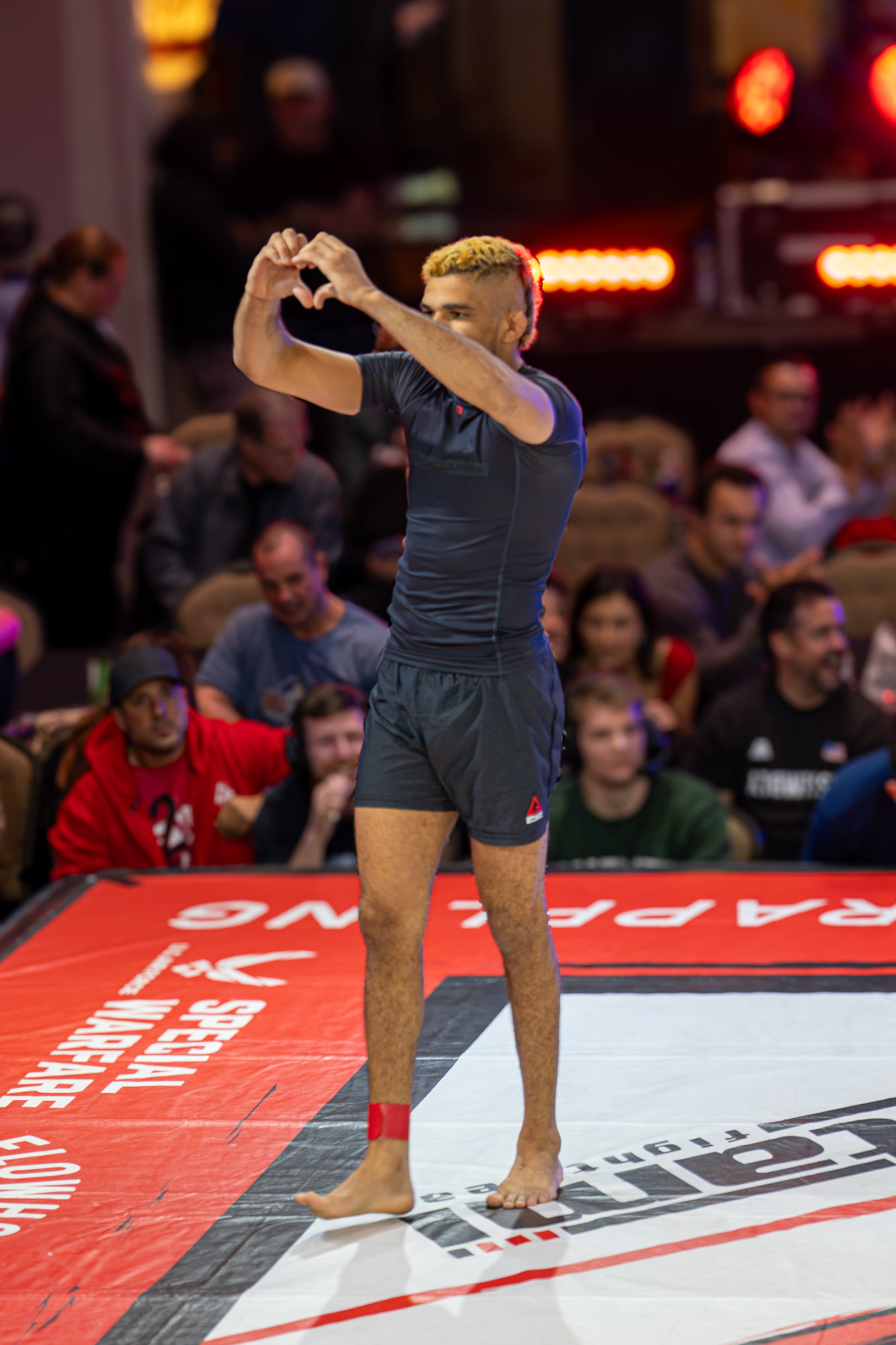 Wellington Andrade making a heart with his hands toward the crowd.