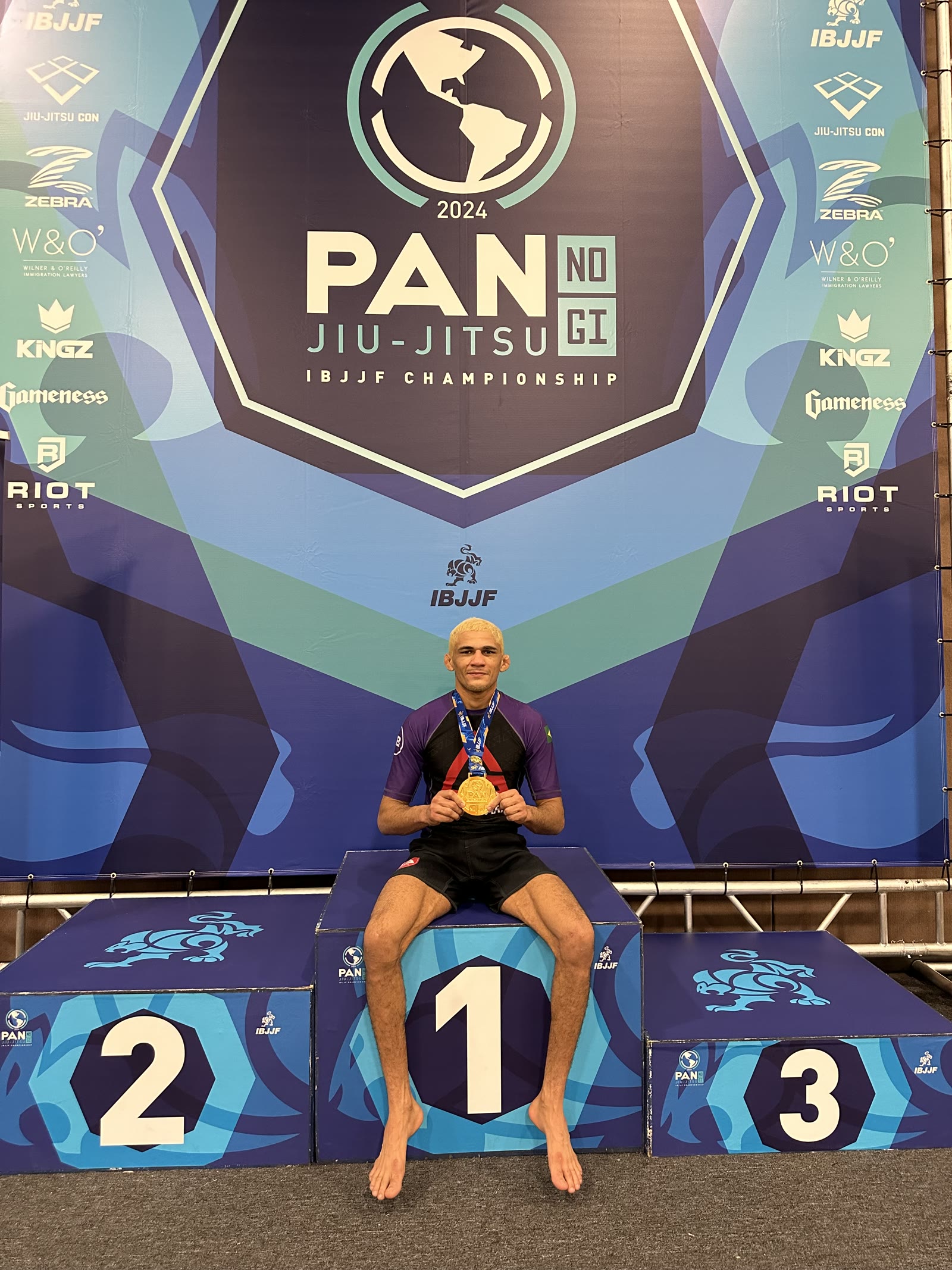 Wellington Andrade on the first-place step at the 2024 IBJJF Pan No-Gi, gold medal in his hands.